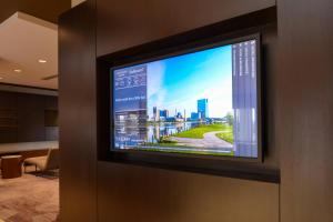 a television on a wall with a city on it at Courtyard by Marriott Toledo North in Toledo