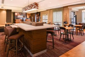 a bar in a hotel lobby with chairs and tables at Courtyard by Marriott Toledo North in Toledo