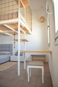 ein kleines Zimmer mit einem Etagenbett und einer Treppe in der Unterkunft Κατοικία Uppolis με θέα τα νησιά in Ano Syros