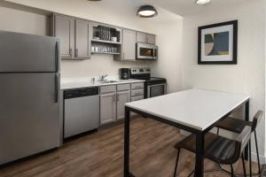 a kitchen with a white table and a refrigerator at Residence Inn by Marriott San Francisco Airport San Mateo in San Mateo