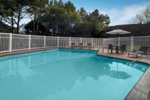 a large swimming pool with a white fence at Residence Inn by Marriott San Francisco Airport San Mateo in San Mateo