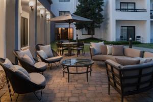 a patio with couches and a table and chairs at Courtyard by Marriott Memphis East/Park Avenue in Memphis