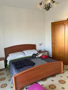 a bed with a wooden frame in a bedroom at Le case di Priscilla in Donnalucata