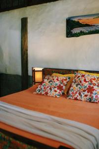 Una cama con dos almohadas encima. en Praia do Rosa Kaora Cabanas, en Praia do Rosa