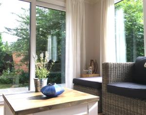 een woonkamer met een tafel en een groot raam bij Sunnychalet in Beekbergen