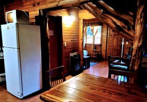 una cocina con nevera y una mesa en una cabaña en Complejo Aiken en Villa Traful