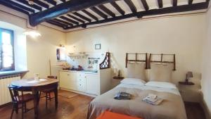 a bedroom with a bed and a table and a kitchen at Le Residenze Ristori in Cortona