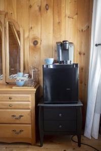 a tv sitting on top of a table next to a dresser at Hébergement "La Maison en Bois Rond" in Sainte-Marie