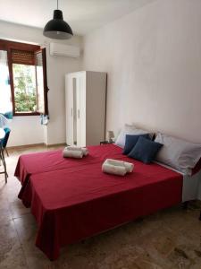 a bedroom with a red bed with two pillows on it at Sa Perda Bianca 8 in Cagliari