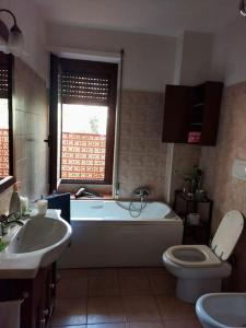 a bathroom with a tub and a toilet and a sink at Sa Perda Bianca 8 in Cagliari