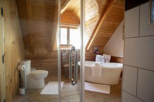 La salle de bains est pourvue de toilettes, d'une baignoire et d'un lavabo. dans l'établissement Hébergement "La Maison en Bois Rond", à Sainte-Marie