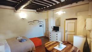 Un dormitorio con una cama y una mesa. en Le Residenze Ristori, en Cortona