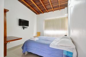 a bedroom with a blue bed and a television at Black Sheep Medellin in Medellín