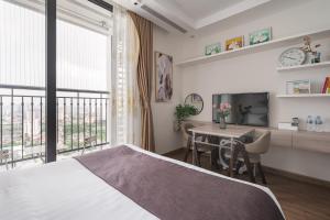 une chambre avec un lit, une table et une télévision dans l'établissement NK#Homestay#Greenbay#Studio#C6, à Hanoï