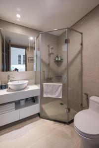 une salle de bain avec une douche avec un lavabo et des toilettes dans l'établissement NK#Homestay#Greenbay#Studio#C6, à Hanoï