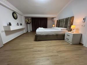 Habitación grande con cama y mesita de noche en Apartment Elbasan city center 2 en Elbasan