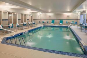 uma grande piscina com cadeiras e mesas em TownePlace Suites by Marriott Ottawa Kanata em Ottawa