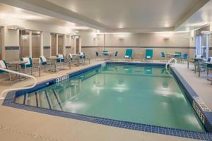 a large swimming pool with chairs and tables at TownePlace Suites by Marriott Ottawa Kanata in Ottawa