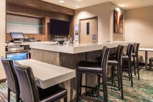 un bar en una habitación con sillas y barra en Residence Inn by Marriott St. Louis Westport en Maryland Heights