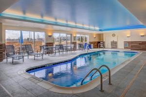 uma piscina num hotel com cadeiras e mesas em Residence Inn by Marriott St. Louis Westport em Maryland Heights