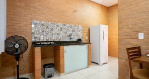 uma cozinha com um balcão e um frigorífico em Flats Oliveira em Pirenópolis