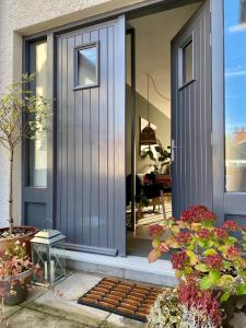 a house with a blue door and some flowers at The Green Room guest suite in Belfast