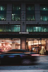 a car driving in front of a building at night at The St. Regis Toronto in Toronto