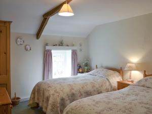 1 dormitorio con 2 camas y ventana en The Cottage, en Sinnington