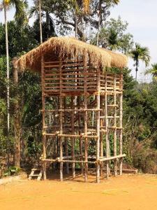 a bamboo hut with a straw roof on the beach at Casa Maria Mystica apartments, Mananthavady, Wayanad in Mānantoddy
