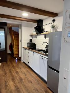 a kitchen with white cabinets and a refrigerator at Domek w Karkonoszach in Karpacz