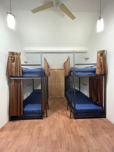 2 Etagenbetten in einem Zimmer mit Deckenventilator in der Unterkunft Gorga hostel in Timuran