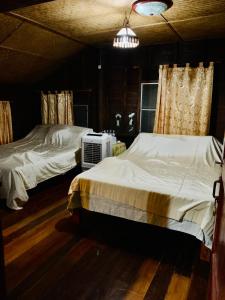 a bedroom with two twin beds and a fan at Phingboon in Saluang