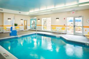 a large swimming pool with blue water in a room at Fairfield Inn and Suites by Marriott Monaca in Monaca