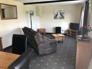 a living room with a couch and a table at Willow cottage, romantic retreat near Honiton Devon in Honiton