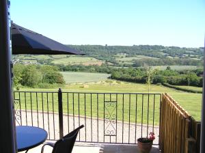 patio con mesa y sillas en el balcón en Willow cottage, romantic retreat near Honiton Devon en Honiton