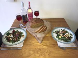 una mesa con dos platos de comida y dos copas de vino en Willow cottage, romantic retreat near Honiton Devon en Honiton