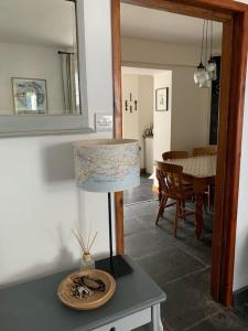 une lampe assise sur une table dans le salon dans l'établissement Seasalt Cottage - Modernised traditional cottage, Sleeps 5,short walk to beaches, town, amenities, à Pembrokeshire