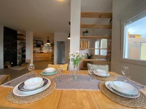 una mesa de comedor con platos y vasos. en Nueve Pies Surf house, en Las Palmas de Gran Canaria