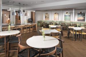 ein Restaurant mit Tischen und Stühlen und eine Bar in der Unterkunft Fairfield Inn & Suites by Marriott Athens in Athens