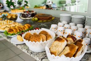 a table with various types of bread and pastries at Costa do Rio Hotel in Petrolina