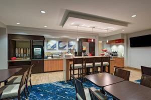 a restaurant with tables and chairs and a bar at TownePlace Suites by Marriott Monroe in Monroe