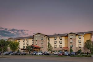 un grand immeuble avec des voitures garées dans un parking dans l'établissement TownePlace Suites by Marriott Monroe, à Monroe