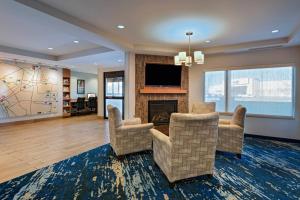 sala de estar con 2 sillas y chimenea en TownePlace Suites by Marriott Monroe, en Monroe