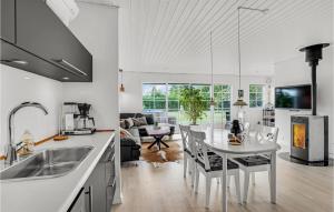 uma cozinha e sala de estar com uma mesa branca e cadeiras em 3 Bedroom Amazing Home In Kirke Hyllinge em Kirke-Hyllinge