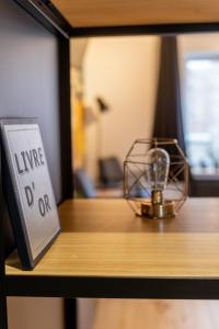 a sign sitting on a shelf next to a shelf at Ardenne BnB gîte urbain avec terrasse in Marche-en-Famenne