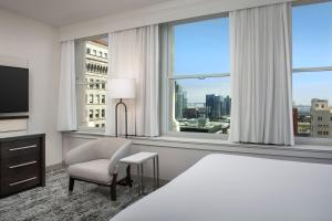 um quarto de hotel com uma cama, uma cadeira e janelas em Courtyard by Marriott San Diego Downtown em San Diego