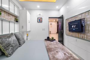 Zimmer mit Sofa und TV an der Wand in der Unterkunft Homlee Villa Apartment with kitchen in East Delhi- Ghaziabad in Ghaziabad