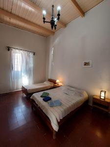 a bedroom with two beds and a chandelier at Postales del Tiempo in Tilcara
