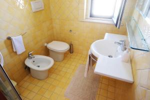 uma casa de banho amarela com um lavatório e um WC em Vistazzurra B&B em Ancona