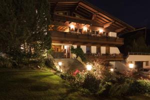 uma casa com luzes nas escadas à noite em Garni - Hotel Rinner Julia em Laces
